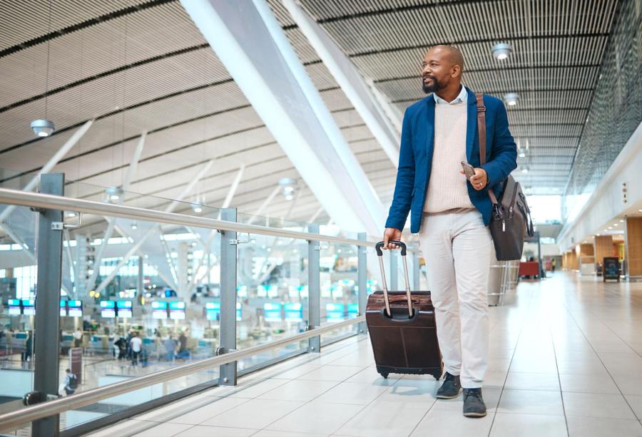 Business traveller walking through an airport terminal with a suitcase